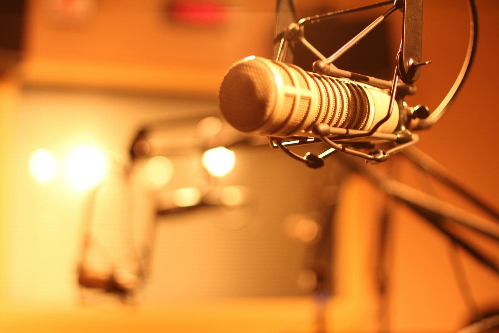 An empty radio studio, two microphones facing each other across the desk with nobody there