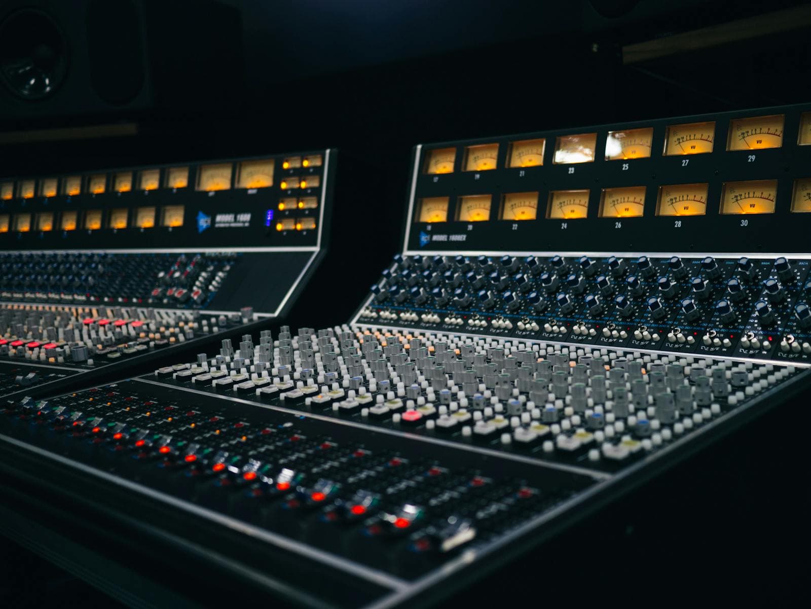 Rows of amber-lit channel meters on a professional studio mixing console