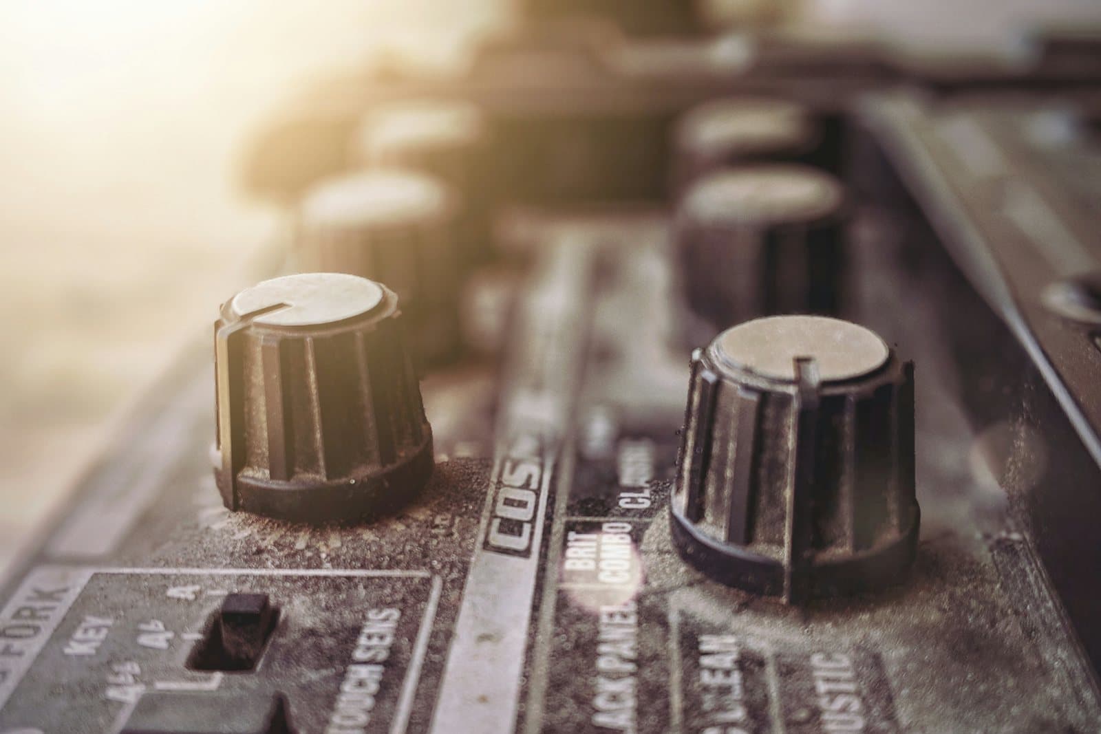 Sunlit knobs on a vintage audio mixer, up close