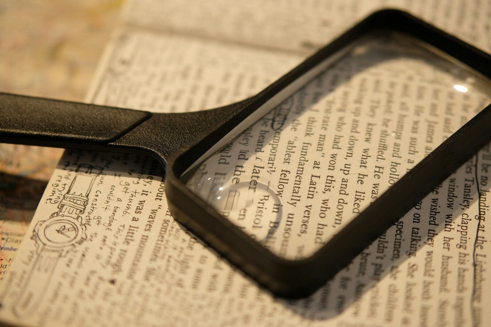 A magnifying glass resting on a page of small printed text